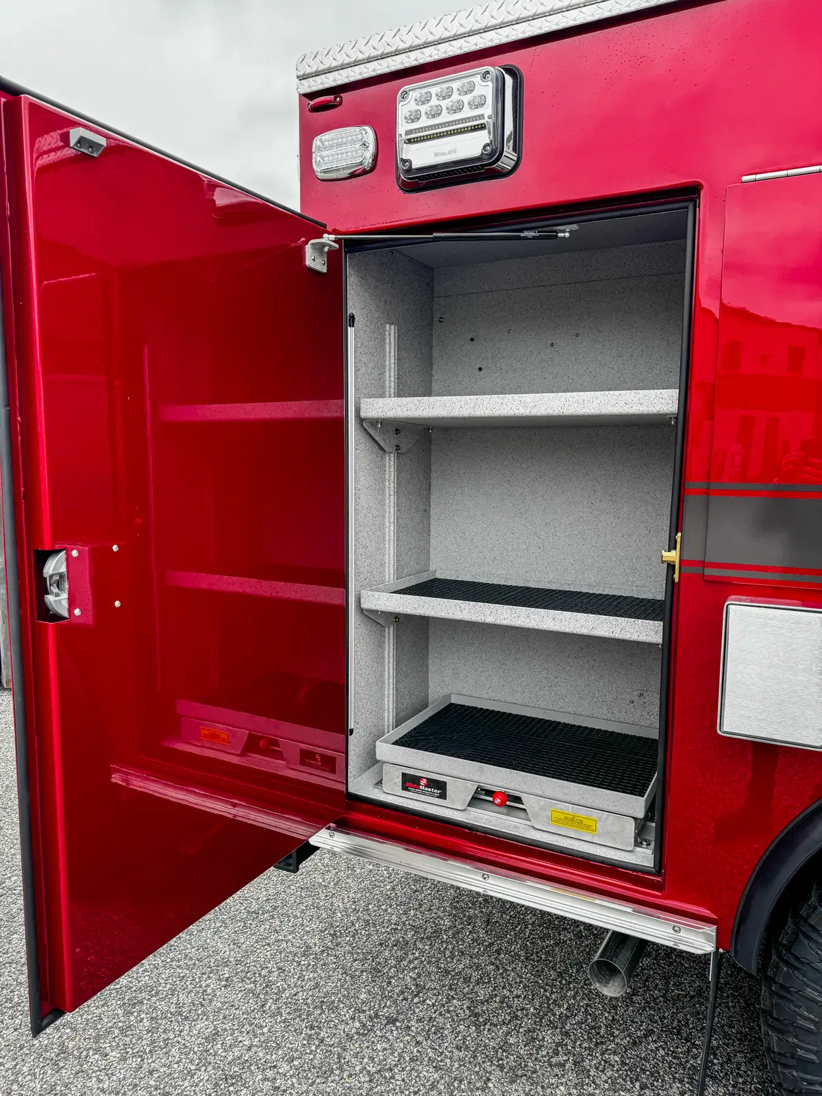 Lower side compartment interior view with shelf and lower tray edge.